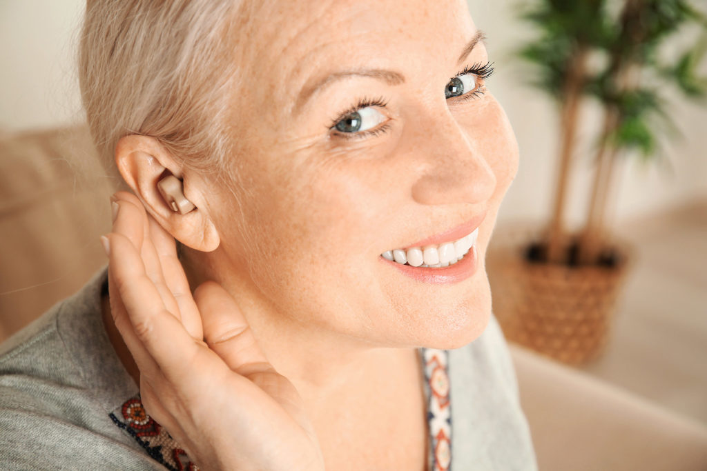 happy woman with hearing aid
